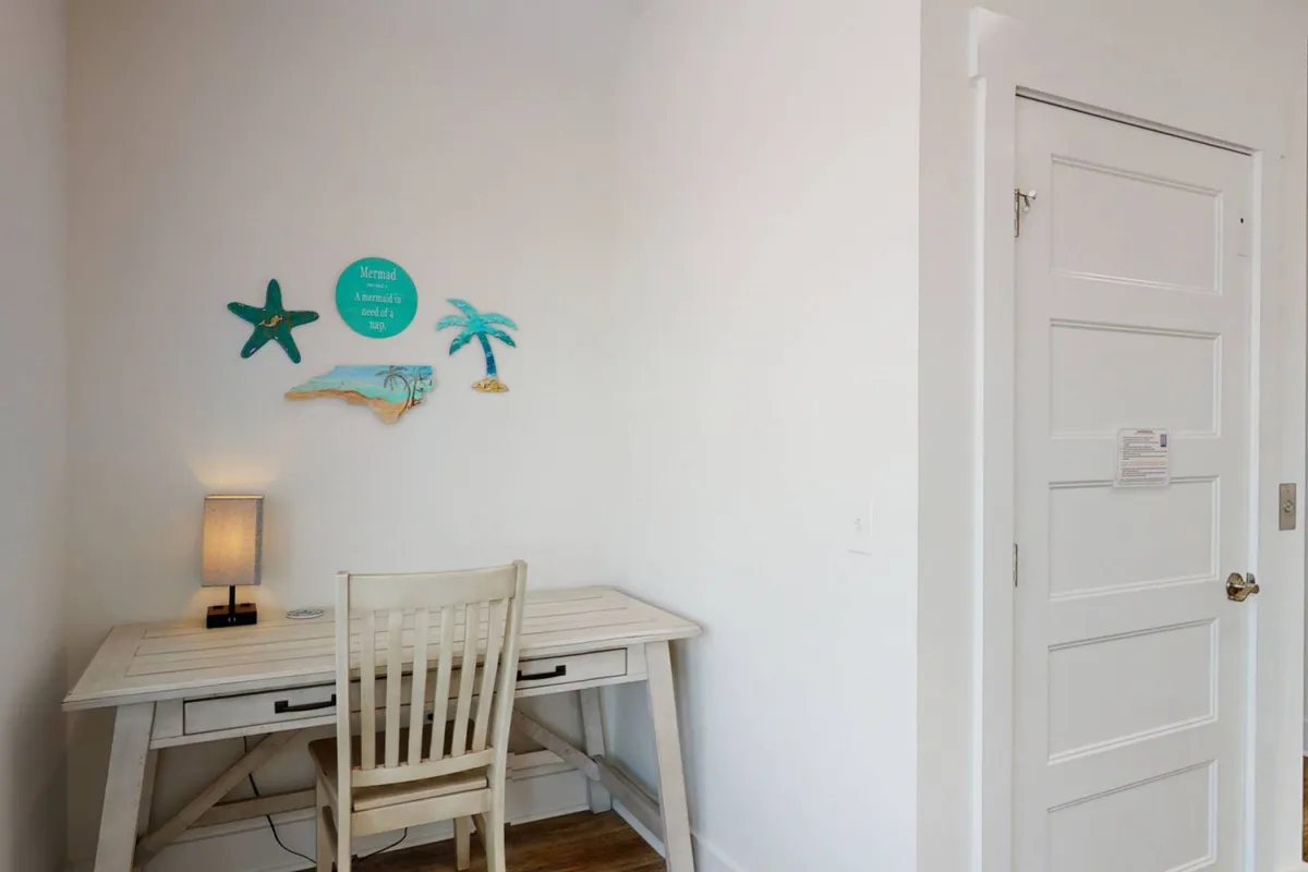 A dedicated workspace featuring a sleek desk and comfortable chair, accented by tasteful decorative wall art and a well-placed lamp. The setting is quiet and well-lit, offering an inspiring environment for productivity, reading, or studying.